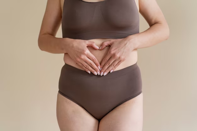 Mulher fazendo gesto de coração em direção ao seu intestino simbolizando carinho e cuidado