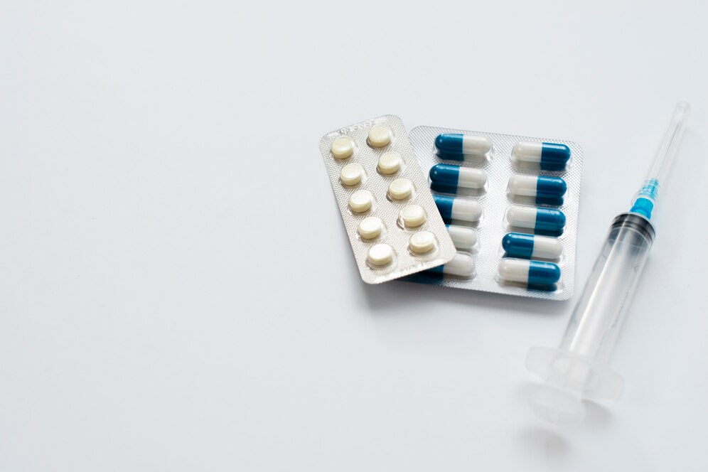 Imagem de cartelas de remédios e seringa.