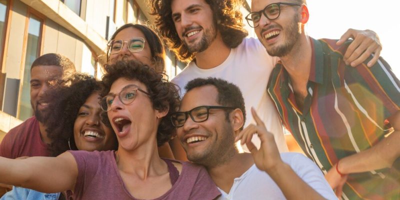 Grupo de amigos jovens adultos interagindo em uma foto.